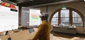 Persona utilitzant l'Apple Vision Pro per interactuar amb múltiples pantalles virtuals, mostrant aplicacions com missatgeria, reserves d'hotels i plans detallats en un entorn immersiu.